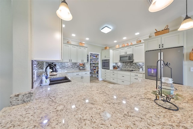 kitchen featuring decorative backsplash, stainless steel appliances, sink, white cabinets, and hanging light fixtures