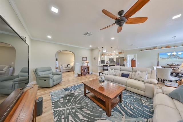 living room featuring ceiling fan, crown molding, and light wood-type flooring