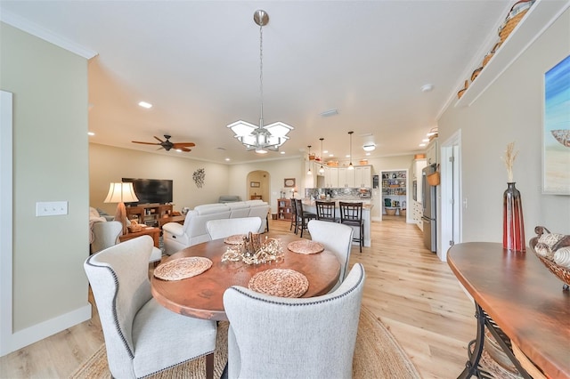 dining room featuring ceiling fan with notable chandelier, light hardwood / wood-style floors, and crown molding