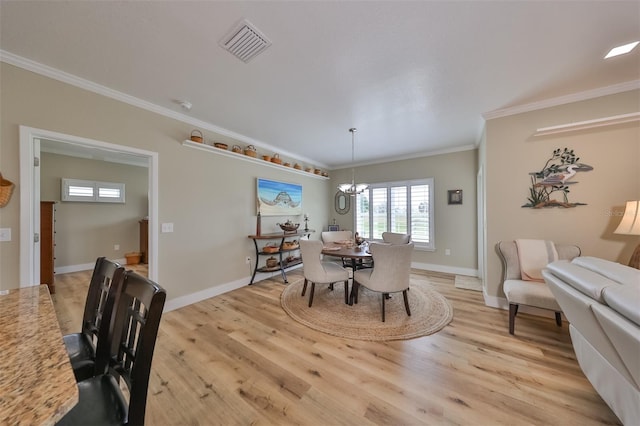 dining room with a notable chandelier, light hardwood / wood-style floors, and ornamental molding