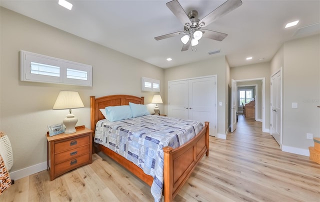 bedroom with light wood-type flooring, a closet, and ceiling fan