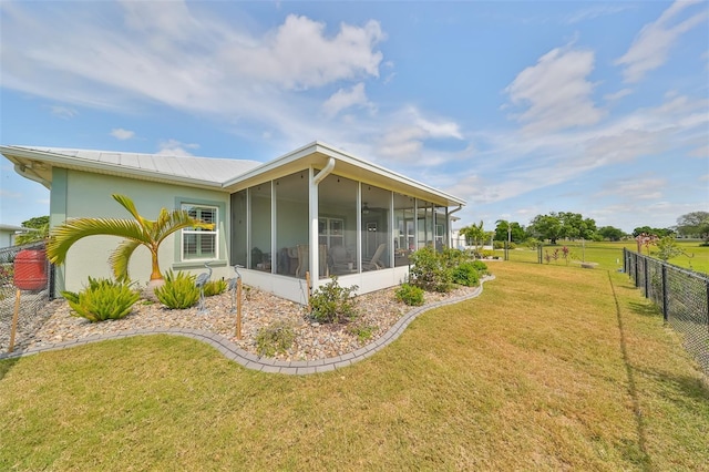 view of side of home featuring a lawn and a sunroom