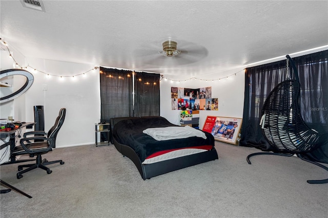 carpeted bedroom featuring ceiling fan and a textured ceiling