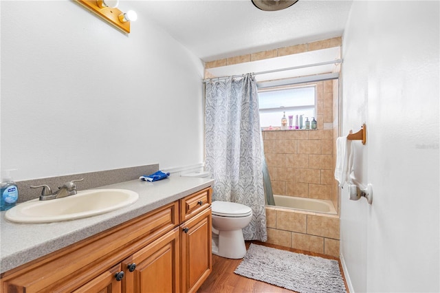 full bathroom with hardwood / wood-style floors, vanity, toilet, and shower / tub combo with curtain