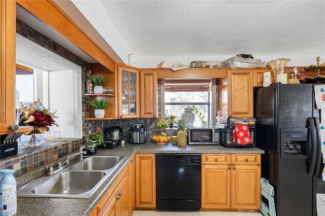 kitchen featuring tasteful backsplash, sink, light tile patterned flooring, and black appliances