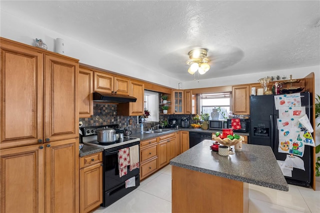 kitchen featuring a breakfast bar, a center island, black appliances, decorative backsplash, and ceiling fan