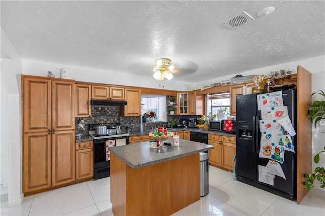 kitchen featuring tasteful backsplash, ceiling fan, black appliances, a center island, and light tile patterned flooring