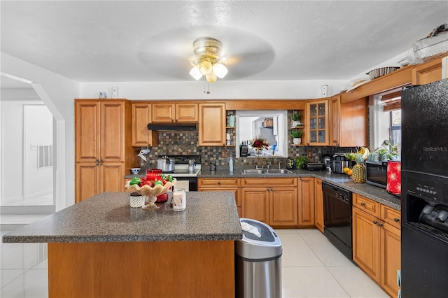 kitchen featuring light tile patterned flooring, a center island, black appliances, and sink