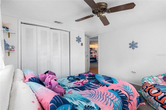 carpeted bedroom featuring ceiling fan and a closet