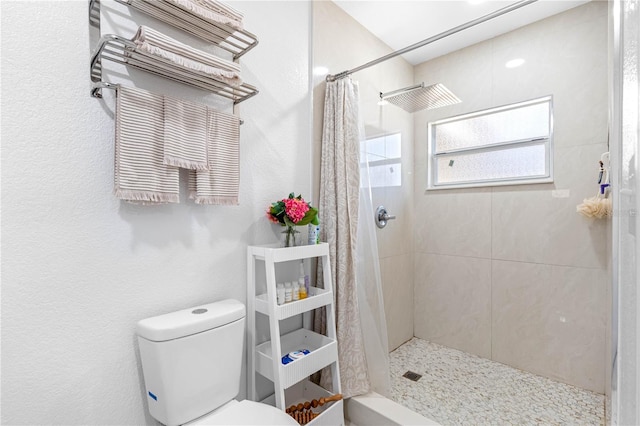 bathroom featuring walk in shower and toilet