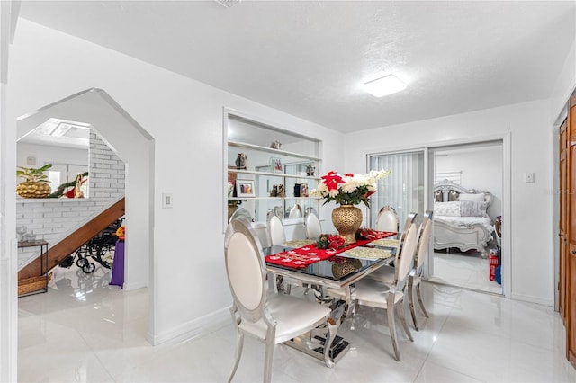 dining room featuring built in shelves and a textured ceiling