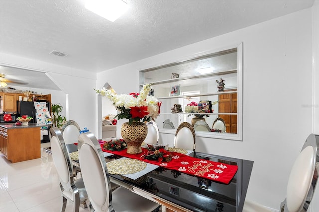 tiled dining room with a textured ceiling