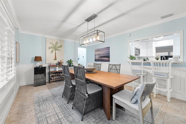 dining space with light tile patterned floors and ornamental molding