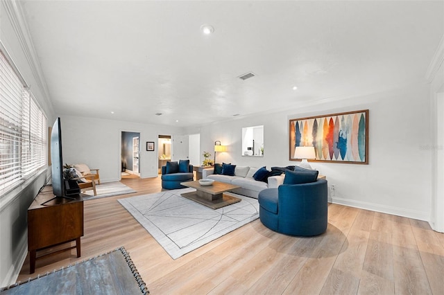 living room featuring crown molding and light hardwood / wood-style flooring