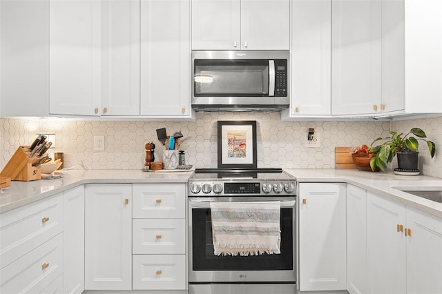 kitchen with backsplash, stainless steel appliances, and white cabinetry