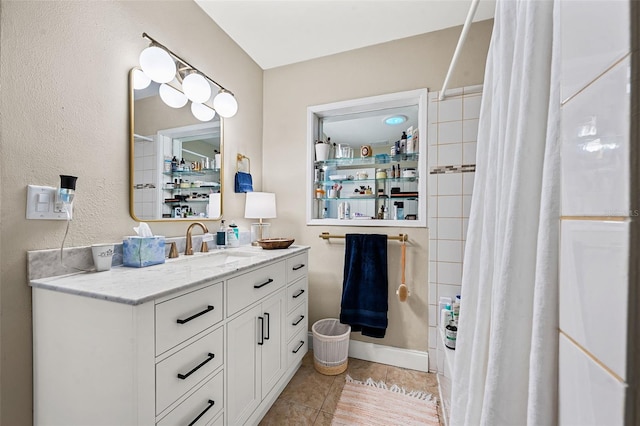 bathroom with tile patterned flooring, vanity, and walk in shower