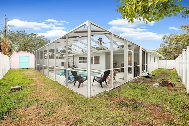 back of property with a lawn, a fenced in pool, a lanai, a storage unit, and a patio