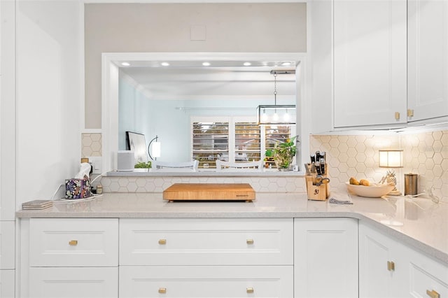 interior space with decorative backsplash, white cabinetry, crown molding, and decorative light fixtures