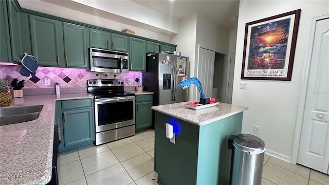 kitchen with light tile patterned floors, tasteful backsplash, appliances with stainless steel finishes, and green cabinetry