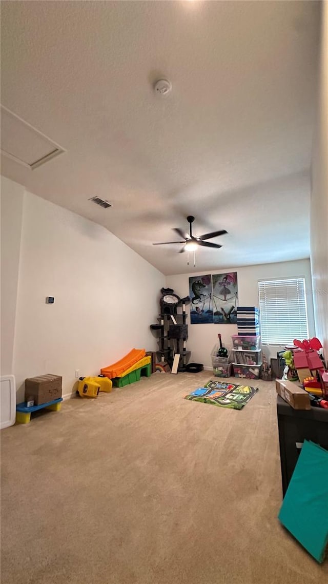 recreation room featuring a ceiling fan, visible vents, and carpet flooring