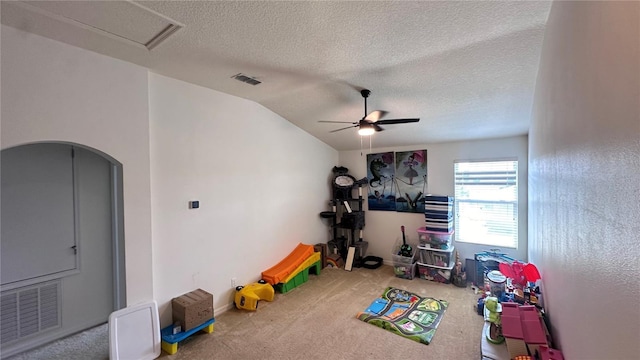 rec room with carpet, ceiling fan, visible vents, and vaulted ceiling