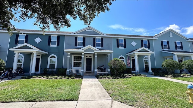 view of property with a front yard and stucco siding