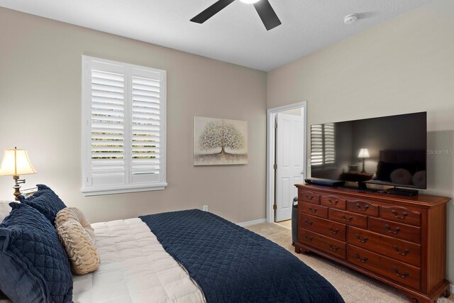 bedroom featuring ceiling fan and light carpet