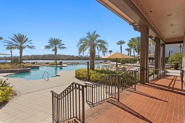 view of swimming pool with a water view and a patio area