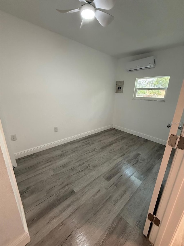 unfurnished room featuring ceiling fan, dark hardwood / wood-style floors, and a wall mounted AC