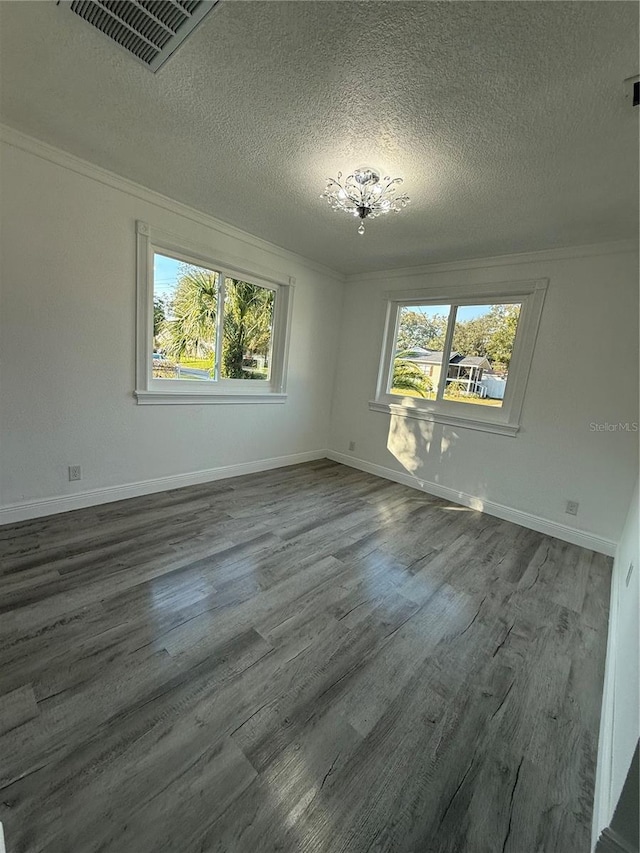 unfurnished room with hardwood / wood-style flooring, ornamental molding, and a textured ceiling