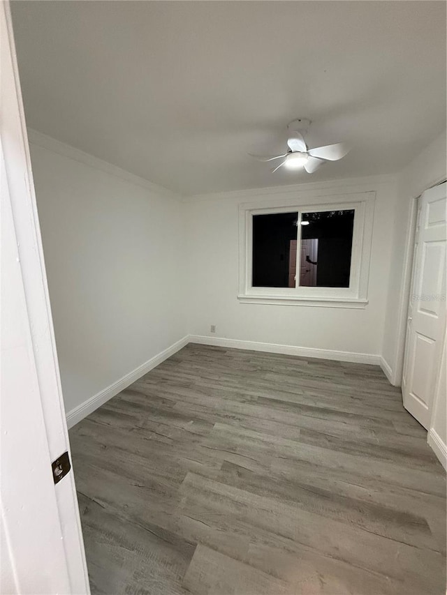 empty room with hardwood / wood-style floors and ceiling fan