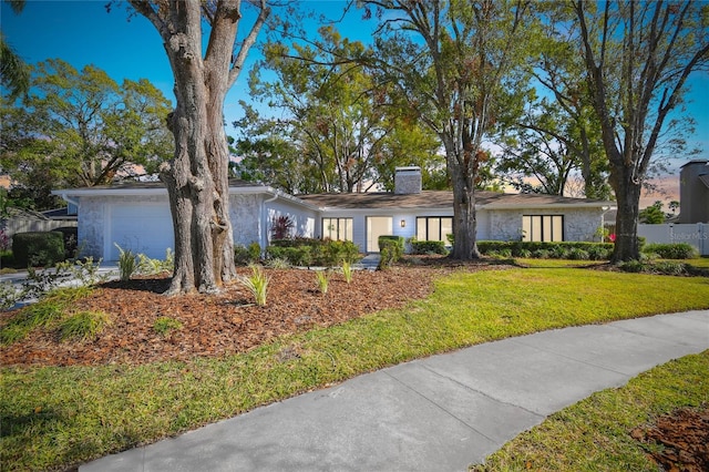 ranch-style home featuring a front lawn and a garage