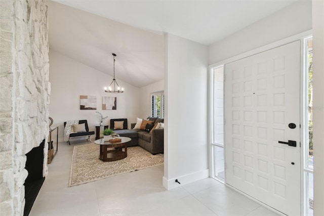 foyer featuring a chandelier, light tile patterned floors, and vaulted ceiling