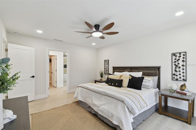 bedroom with light wood-type flooring, ensuite bathroom, and ceiling fan