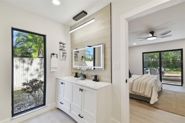 bathroom with hardwood / wood-style floors, ceiling fan, and vanity