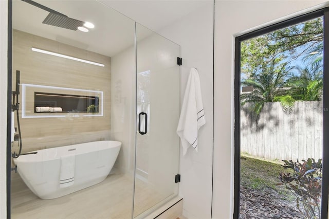 bathroom featuring independent shower and bath