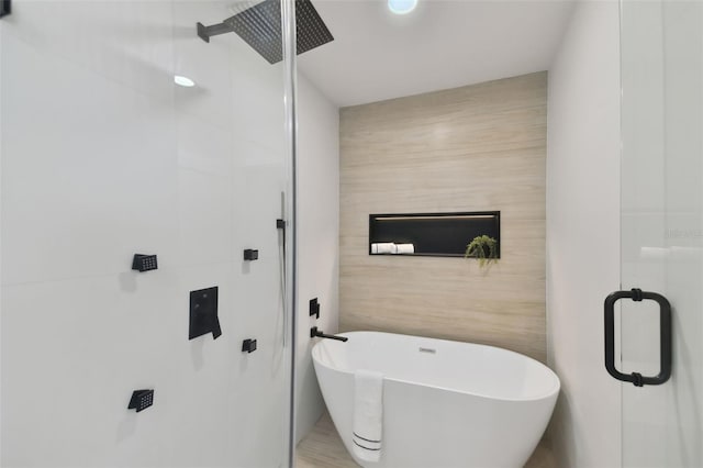 bathroom featuring plus walk in shower and tile walls