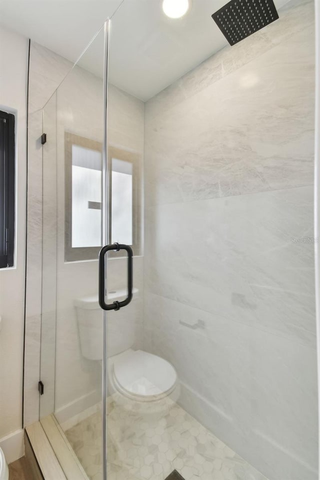 bathroom with toilet and a shower with shower door