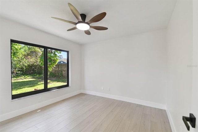 empty room with ceiling fan and light hardwood / wood-style flooring