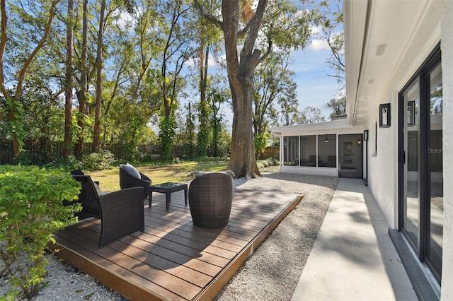 view of patio featuring a wooden deck and a sunroom