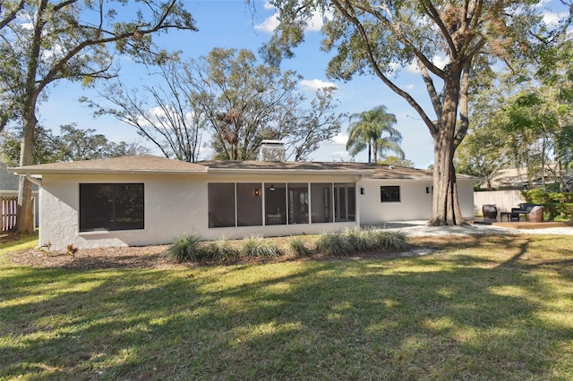 back of house featuring a yard, a patio area, and a sunroom