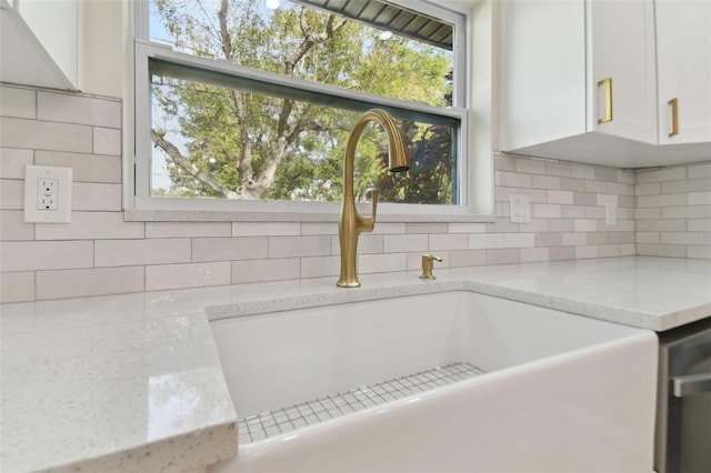 details with white cabinets, light stone counters, sink, and tasteful backsplash