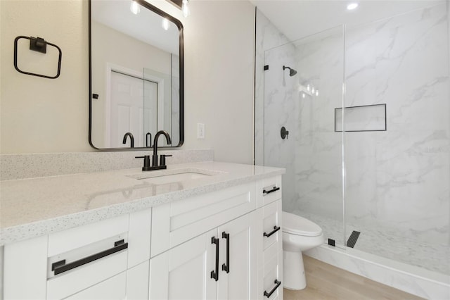 bathroom with vanity, hardwood / wood-style flooring, toilet, and walk in shower