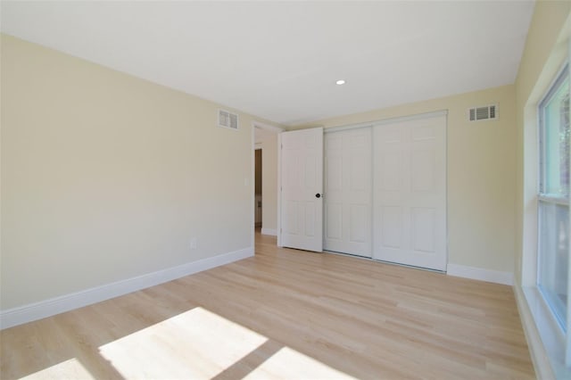 unfurnished bedroom featuring a closet and light wood-type flooring