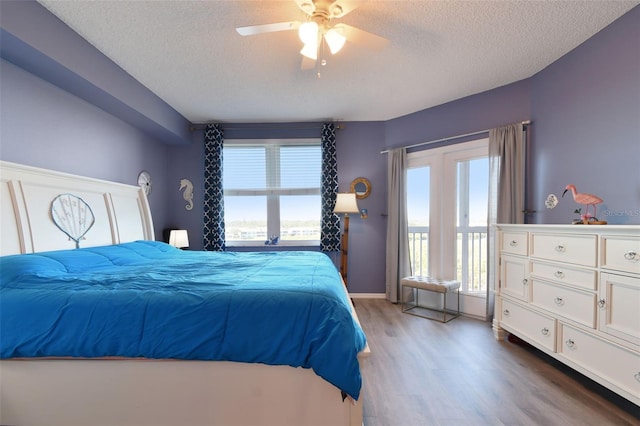 bedroom featuring ceiling fan, a textured ceiling, and wood-type flooring