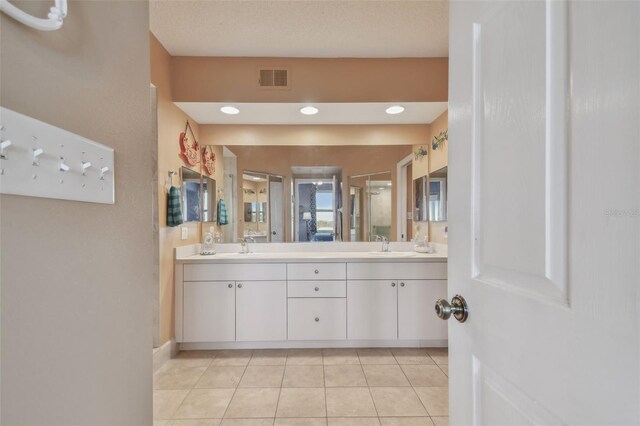 bathroom featuring a shower with door, tile patterned floors, and vanity