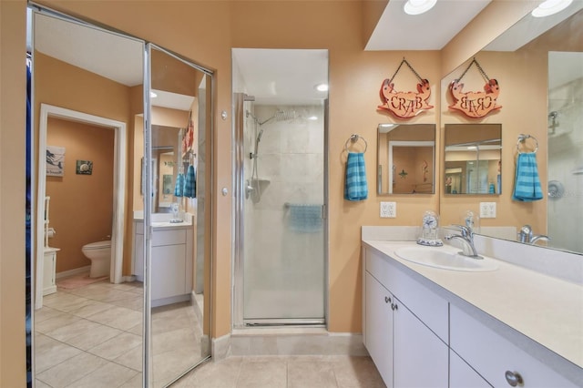 bathroom featuring vanity, toilet, tile patterned floors, and an enclosed shower