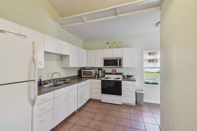 kitchen with light tile patterned floors, sink, white appliances, and white cabinets