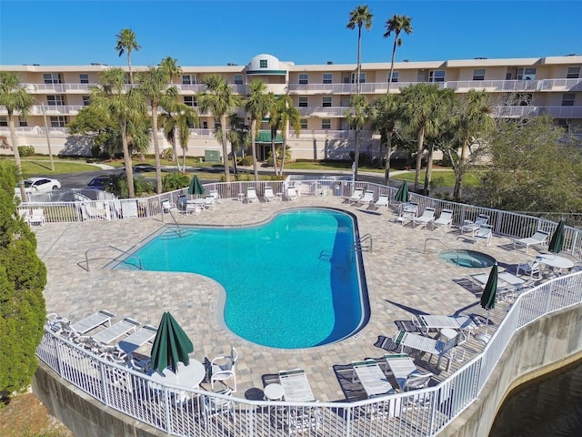 view of swimming pool featuring a hot tub and a patio