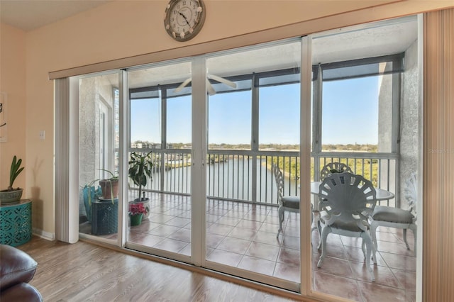 doorway to outside with a water view and wood-type flooring